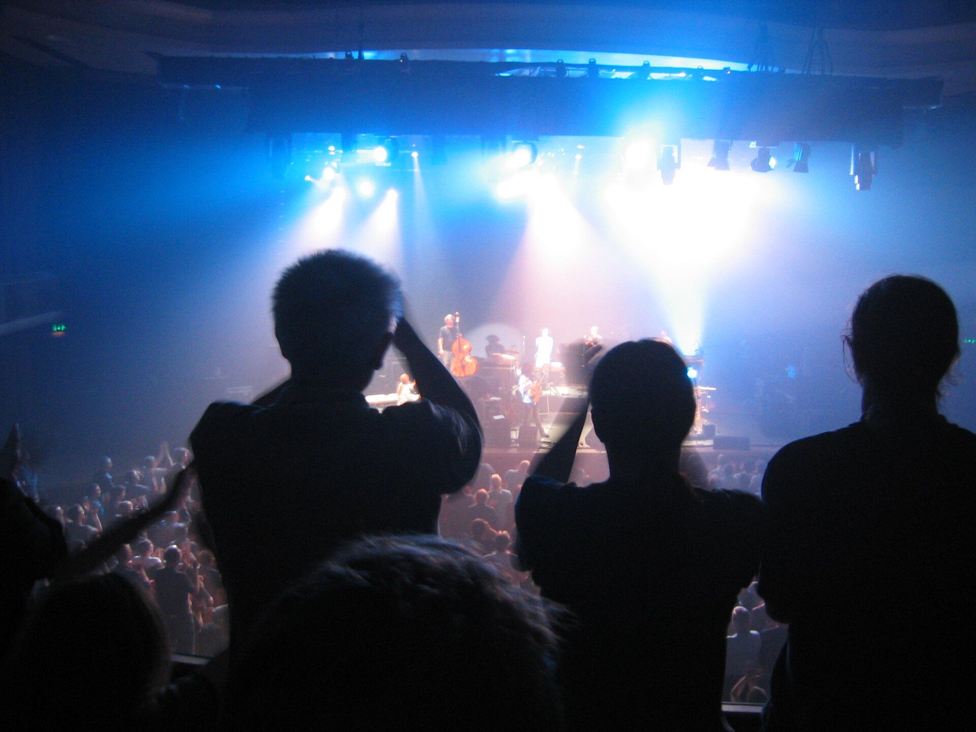 Concertgoers silhouetted against blue stage light at a Pat Metheny Group show in Brighton, England, 2005